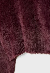Gros plan d'un tissu en fausse fourrure douce bordeaux profond avec une texture dense, moelleuse et des fibres légèrement ondulées sur fond blanc.