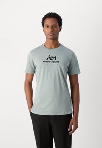 Lichtblauwe katoenen T-shirt met een ronde halslijn en korte mouwen, met het zwarte logo "ANTONY MORATO" gedrukt op de borst.