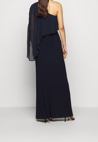 Mörkblå, enaxlad maxiklänning med en flödande chiffongöverdel. Konturformad design, mjuk textur, minimalistisk stil och ankel-längd.