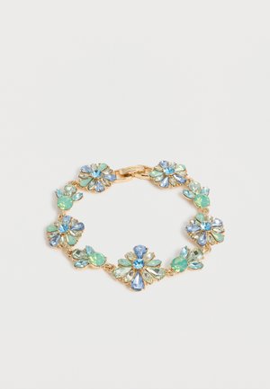 Gold bracelet with alternating floral and round clusters of blue, light green, and clear gemstones on a white background.