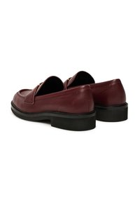 Mocassini in pelle bordeaux con finitura liscia, suole in gomma nera piatta e design slip-on caratterizzato da punta rotonda e dettagli decorativi.