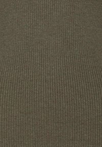 Gros plan sur un tissu en maille côtelée vert olive avec une texture verticale.