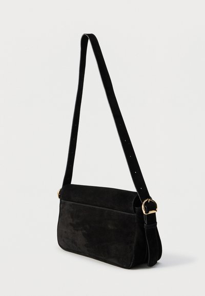 Μαύρη σουέντ τσάντα ώμου με ρυθμιζόμενο λουράκι και χρυσή αγκράφα, ορθογώνιο σχήμα με στρογγυλεμένες άκρες, σε απλό ανοιχτό φόντο.