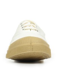 Baskets en toile blanches avec une semelle en caoutchouc naturel texturé, un devant lacé et une pointe arrondie. Design simple sans embellissements visibles.