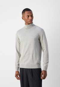 Pulover turtleneck de culoare gri deschis, realizat dintr-un material tricotat moale. Prezintă detalii cu margini ribbate, o siluetă ajustată și un logo discret pe tiv.