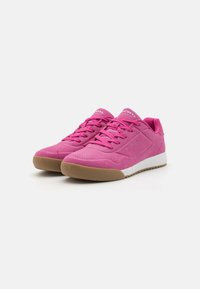 Sneaker sintetiche rosa con una finitura testurizzata, design con lacci, area delle dita perforata e suola in gomma naturale. Accenti bianchi sulla suola.