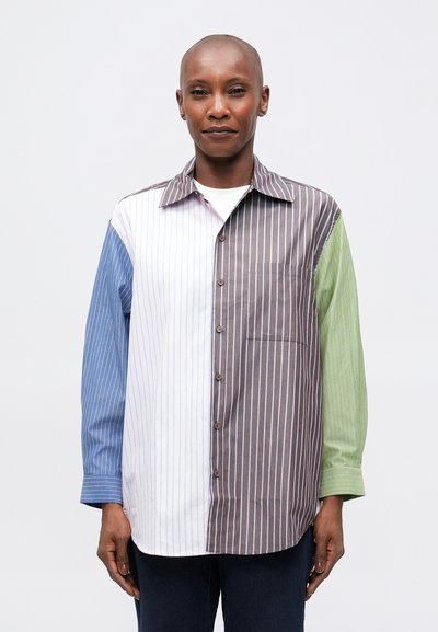 Chemise rayée présentant des sections bleues, blanches, brunes et vertes. Design à boutons avec col et poche poitrine. Manches longues.