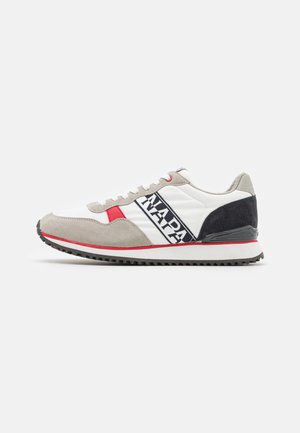 Sneaker sportive con tomaia in pelle bianca, dettagli in camoscio grigio, elementi di design rossi e blu navy, e suola in gomma nera.