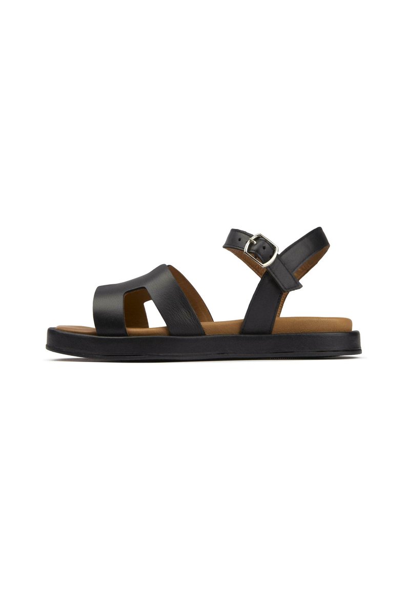 Black leather sandals with a flat sole, open toe design, and adjustable ankle strap. Features a subtle texture and contrasting brown insole.