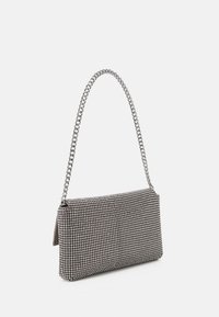 Sac banane avec une forme rectangulaire structurée, recouvert de strass noirs et argentés, doté d'une bandoulière en chaîne argentée et d'une fermeture à glissière.