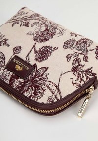 Clutch in tessuto beige con motivo floreale e ricami in color bordeaux, dotato di una zip marrone scuro e accessori in tono oro con etichetta del marchio.