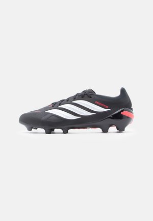 Crampon de football noir avec des rayures blanches et des accents rouges. Présente une tige synthétique texturée, des crampons en caoutchouc et un design épuré.