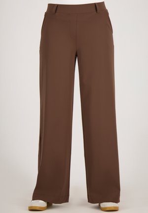 Bruine, wijde broek gemaakt van een zachte, gladde stof. Beschikt over twee zijzakken en een tailleband met lussen voor een riem.