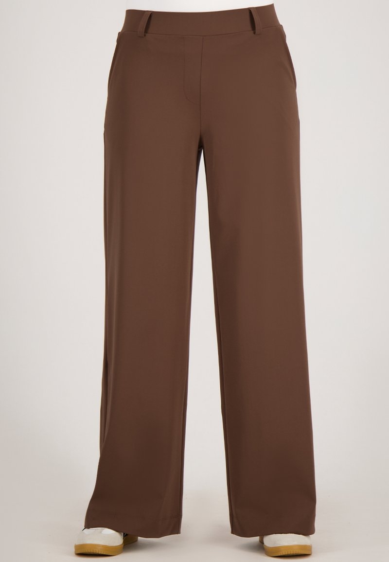 Bruine, wijde broek gemaakt van een zachte, gladde stof. Beschikt over twee zijzakken en een tailleband met lussen voor een riem.