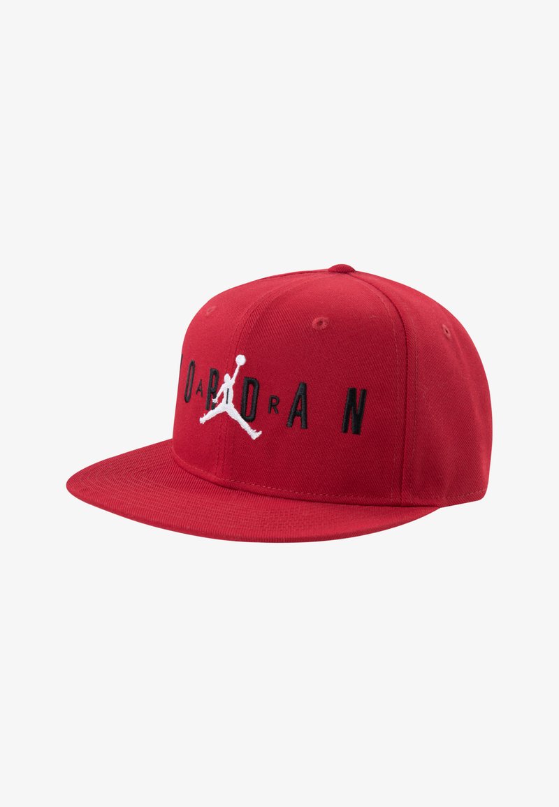 Gorra de béisbol roja hecha de tela texturizada. Presenta una visera plana y el texto bordado en negro "JORDAN" junto con el logo de Jumpman en blanco en la parte frontal.
