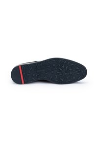 Semelle de chaussure habillée noire avec motif géométrique texturé et bande rouge près du talon, marquée du logo "LLOYD" au centre et au talon.