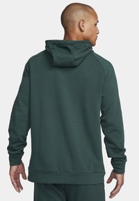 Dark green hoodie with a textured fabric, adjustable drawstring hood, ribbed cuffs, and hem, featuring a simple design and long sleeves.