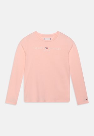 Jasnoróżowa koszulka z długim rękawem wykonana z bawełny, na przodzie z białym logo i napisem "TOMMY HILFIGER EST 1985". Zawiera metkę marki na rękawie.