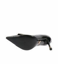 Zapato negro de charol con punta afilada y tacón de aguja, mostrado desde la vista de la suela, con un acento dorado en la punta del tacón y en la hebilla.