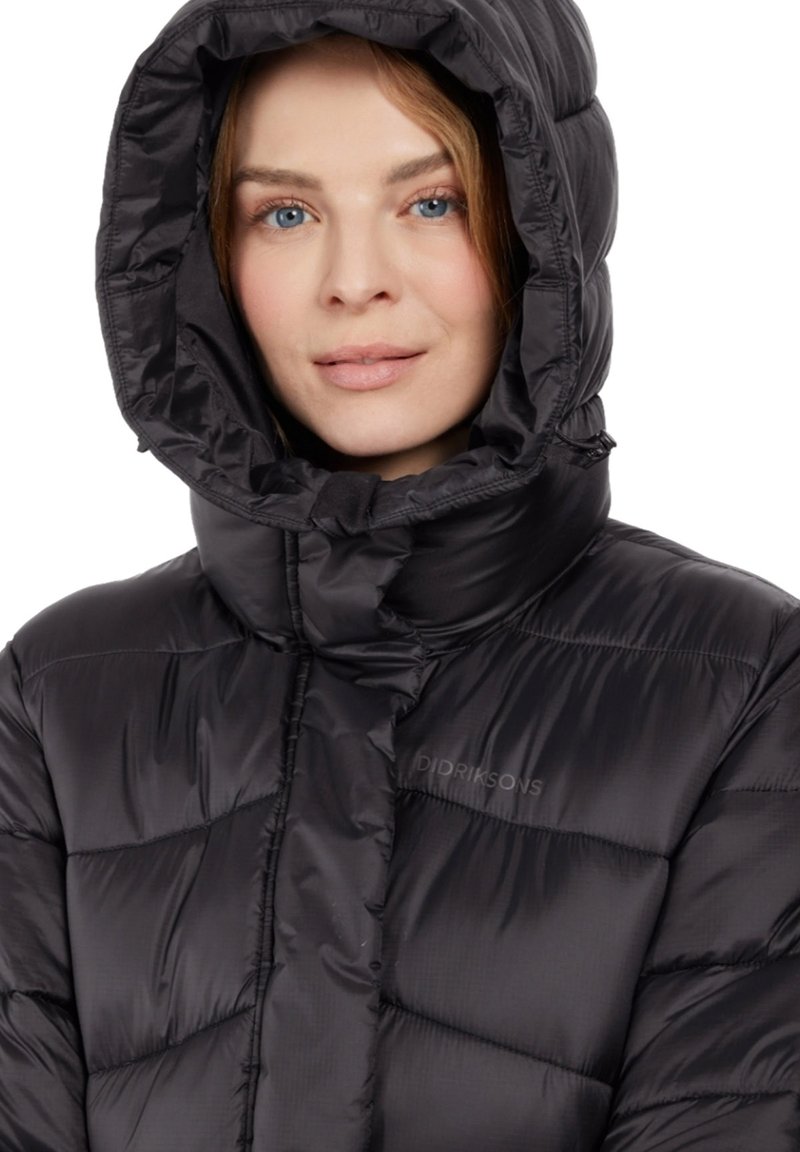 Chaqueta de plumas negra con una gran capucha, diseño acolchado y logotipo en relieve en el pecho. Fabricada con un material brillante y ligero.
