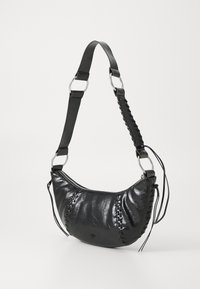 Schwarze Lederhandtasche mit geschwungener Form, Reißverschluss und dekorativer Naht. Verfügt über einen metallischen Hardware-Tragegurt mit Stoffakzenten.