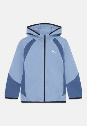 Veste à zip bleu clair avec capuche. Comprend des sections contrastantes bleu foncé, des poches latérales et un logo blanc sur la poitrine gauche.
