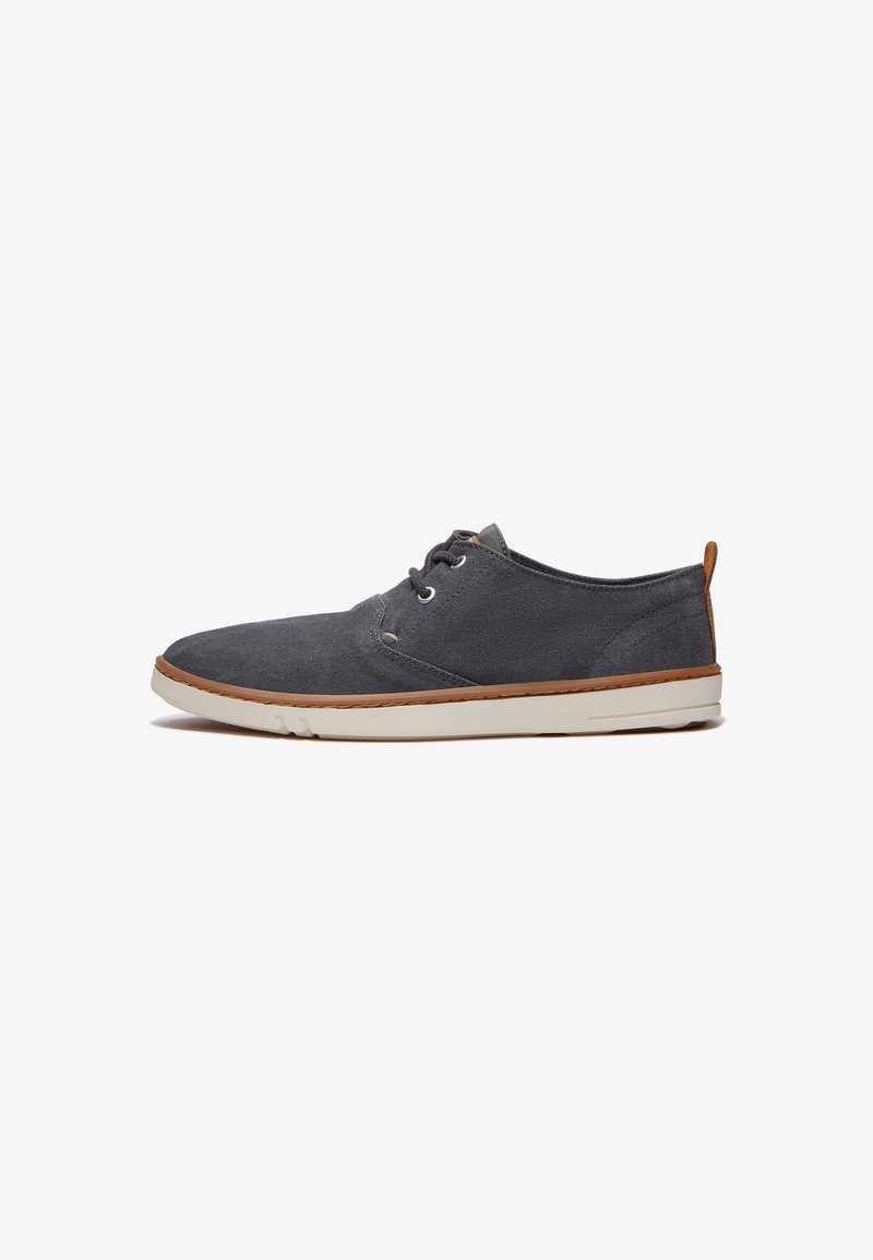 Gray canvas shoes with a low profile, white rubber sole, and brown leather accent on the heel. Features laces and stitched detailing.