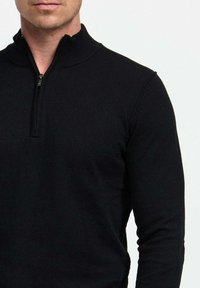 Fekete, cipzáros pulóver magas gallérral, puha anyagból készült, hosszú ujjú és testhezálló fazonú. Minimalista és sokoldalú stílus.
