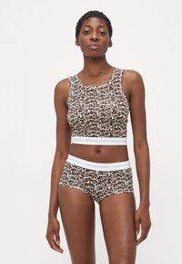 Športová podprsenka a zodpovedajúce šortky s leopardím vzorom, vyrobené z bavlneného zmesi, s bielym elastickým pásom a logom "COPENHAGEN STUDIOS".