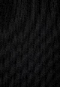 Texturerad svart stickad tyg med en enhetlig utseende, som visar en fin väv och mjuk, lätt elastisk yta.