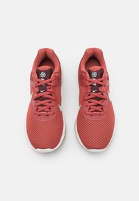 Rode sportieve schoenen met een ademende mesh bovenzijde, veters en een witte rubberen zool. Opvallend mintgroen logo aan de zijkant.