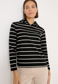 Czarna bluza z kapturem w białe poziome paski, z długimi rękawami i kieszenią na przodzie. Gładka faktura, casualowy design i dopasowany krój.