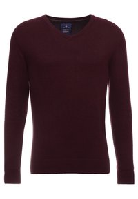 Burgunderfarbener V-Ausschnitt-Pullover aus weichem Stoff. Er hat lange Ärmel und einen gerippten Saum, mit einem Etikett, das im Ausschnitt sichtbar ist.