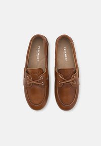 Brune lærloafers med rund tå, med snøredetaljer og metallhull. Teksturert overdel med polstret såle. Merkenavn inni.
