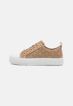 Beige lavtop sneaksko med tekstureret monogramstof, hvid gummisål, guld øjer, snørelukning foran og trækflap ved hælen.
