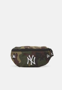Kamouflage fanny pack med dragkedja. Har en vit New York Yankees-logotyp och en MLB-logotyp på sidan. Hållbart tyg.