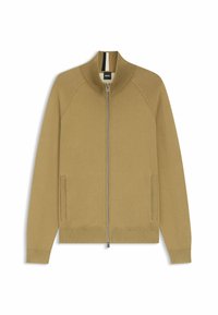 Beżowa kurtka na zamek z wysokim kołnierzem, prążkowanymi akcentami, bocznymi kieszeniami oraz gładką fakturą. Wewnątrz kołnierza znajduje się czarno-biały pasek.