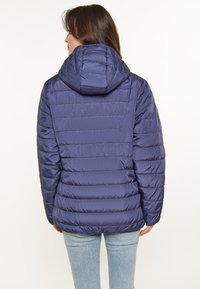 Chaqueta acolchada azul marino con capucha, con textura acolchada, puños elásticos y un diseño ajustado, mostrada desde la parte trasera.