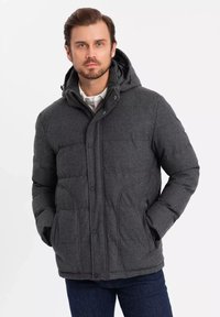 Grå puffjakke med hætte, med en quiltet design, frontknaplukning og to sidelommer. Blød tekstur og polstret for varme.
