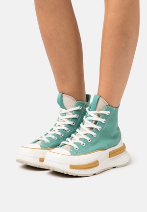 Hoge sneakers van teal canvas, met witte veters, rubberen zolen met beige accenten en een gevoerde kraag voor extra comfort.