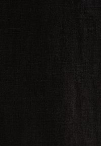 Czarna tkanina lniana o subtelnej teksturze, z miękką, tkana powierzchnią i nieco nieregularnym wzorem.