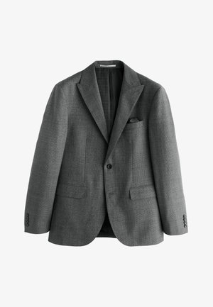 Blazer grigio monopetto con rever a lancia, due tasche frontali con patta, taschino al petto con fazzoletto nero e polsini con bottoni.