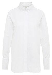 Camisa blanca de manga larga hecha de algodón, con cuello mao, cierre frontal de botones y mangas con puños, todo con una textura suave.