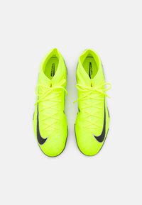 Botas de fútbol Nike Mercurial de color amarillo brillante con una superficie texturizada, logo de swoosh negro y cordones a juego. Diseño ligero con una forma aerodinámica.