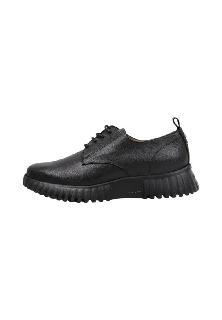 Zapato negro de cuero con cordones, suela gruesa y estriada, y tirador en el talón, mostrado en perfil lateral sobre un fondo blanco.