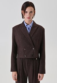 Brauner, zweireihiger, kurz geschnittener Blazer mit vertikalen Nadelstreifen, mit Reverskragen und Knopfdetails, kombiniert mit strukturierten, passenden Hosen.