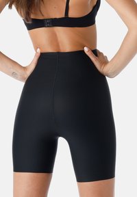 Shorts neri a vita alta realizzati in tessuto elasticizzato, caratterizzati da una superficie liscia e senza cuciture visibili per un aspetto snellente.