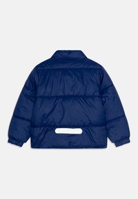 Giubbotto imbottito blu navy con colletto alto, design imbottito, polsini elasticizzati e un dettaglio a loop bianco sul retro vicino all'orlo.
