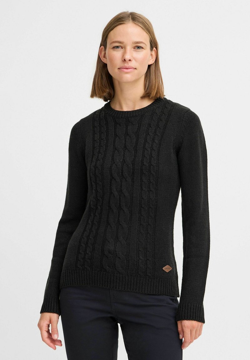 Schwarzer Strickpullover mit strukturiertem Kabelmuster, runder Ausschnitt und gerippten Bündchen. Enthält ein kleines Lederlogo-Patch an der Seite.