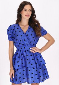 Blaues Wickelkleid mit schwarzen Herzmustern, kurzen Puffärmeln, einem gestuften Rock und einem passenden Gürtel in der Taille. Glattes, leichtes Material.